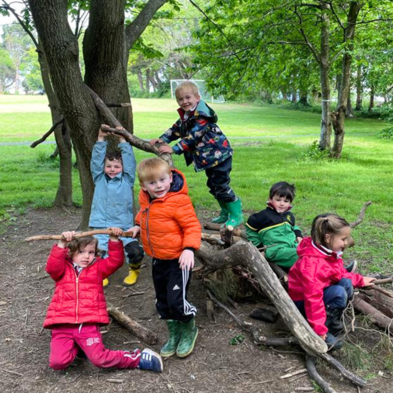 A group from our K2 class climbing on branches and smiling for the camera