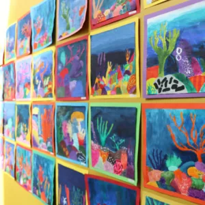 A photo of a wall displaying childrens paintings at the Art Exhibition